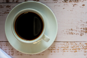 Taza de cafe sobre una tabla de madera vista desde arriba.