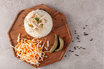 Chicken Pilaf (Tavuklu Pilav) is a traditional Turkish dish made with buttered rice pilaf as a base and boiled chicken breast on top. It is seasoned with salt and peppercorn and served with salad