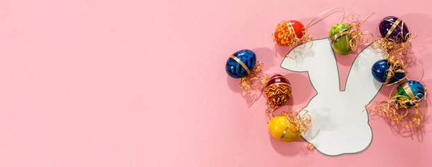 Top view of easter eggs and paper rabbit.