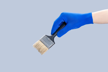 handyman repair minimal concept. worker holding paint brush isolated over gray background