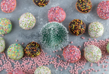 Cookies decorated with sprinkles around pine tree