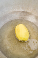 Golden potatoes are fried in boiling oil in a cauldron