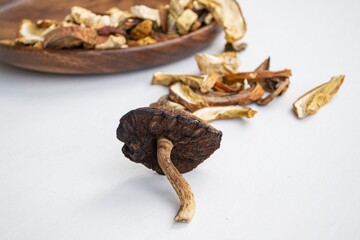 Dried mushrooms on a light background and on wooden plate