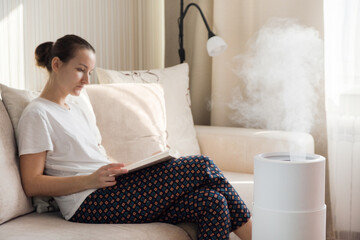 Modern air humidifier, aroma oil diffuser at home. Improving the comfort of living in a house,...
