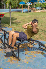 Obraz premium Hombre joven haciendo ejercicios de abdominales en ñu guazu luque asunción al medio día