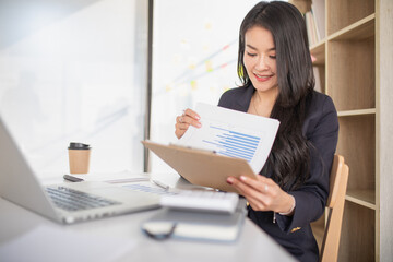 Accounting businesswoman working on laptop computer and analyzing real estate investment data, Financial and tax systems concept.