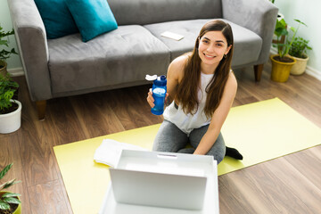 Young woman resting on an exercise mat in the living room