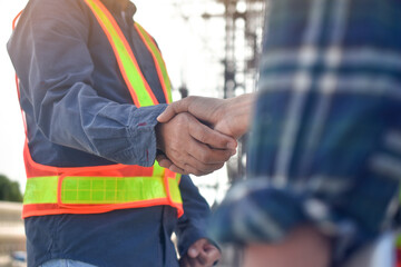 Two Engineer shake hand agreement success project at construction site