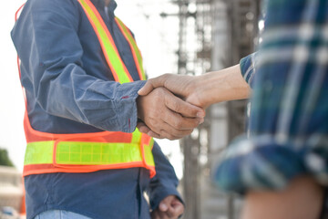Two Engineer shake hand agreement success project at construction site