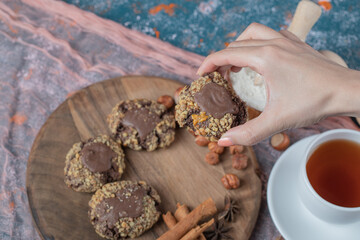 Chocolate cookies with nuts, cinnamon and anise served with a cup of tea