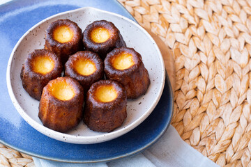 A plate of french pastries, Canelés de Bordeaux with a blue napkin