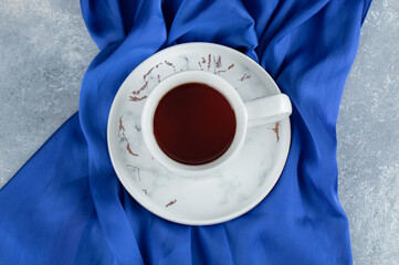 Cup of hot tea on blue cloth