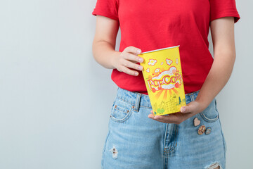 Female model in red shirt holdina a popcorn box