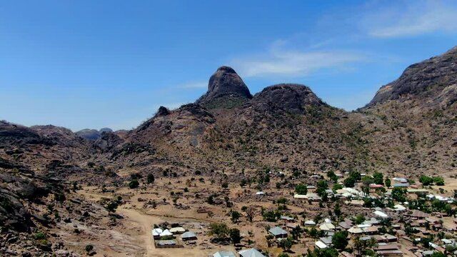 A suburb of the city of Dass nestled beneath the rugged mountains of the Nigerian state of Bauchi - aerial pull back view