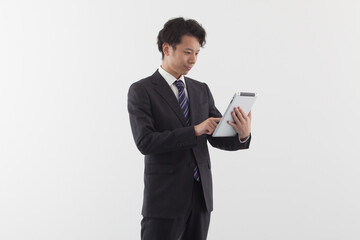 A young Asian businessman using a tablet