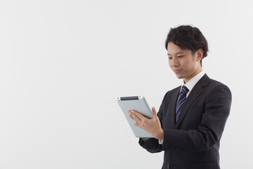 A young Asian businessman using a tablet