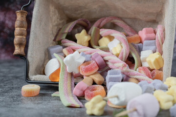 Colorful marshmallow and jellybeans inside a mini basket