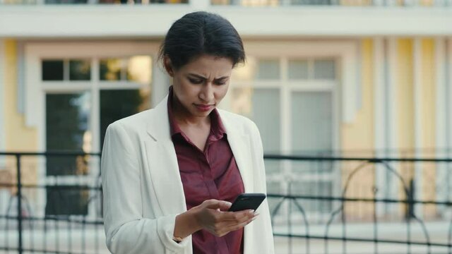 Mixed race businesswoman feeling stressed outdoors. Upset woman getting bad news