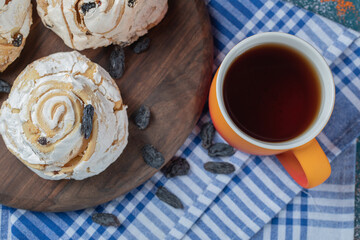 Fried meringue cookie with black raisines and a cup of tea
