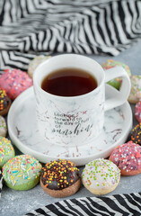Tasty glazed cookies and cup of tea on marble background