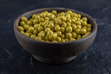 Close up photo of Bowl full with Green marinated olives on black background