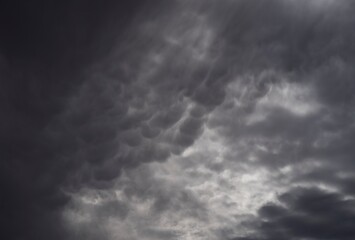 Obraz premium This image shows gentle sun rays illuminating a spot in a dark sky filled with clouds. 