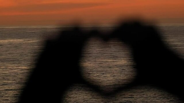 Making Heart Form With Hands And Fingers during holiday trip. Loving the ocean during sunset.
