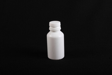 white plastic medicine bottle, black background