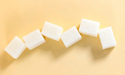A few rectangular sugar cubes on a beige background.
