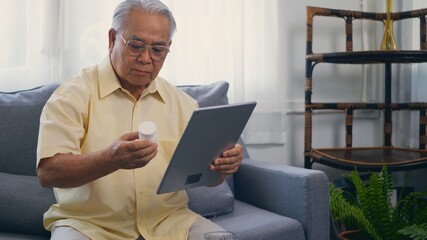 Asian elderly patient video call by digital tablet to doctor for inquire about which bottle of...