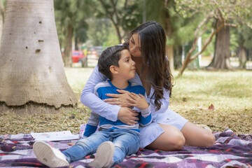 mama e hijo sentados en parque al aire libre