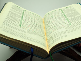 Obraz premium Picture of holy Quran on a wooden table, shoot on a white isolated background