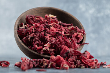 Dry hibiscus tea in wooden bowl