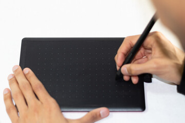 young man holding a stylus pencil with two hands for drawing and animation