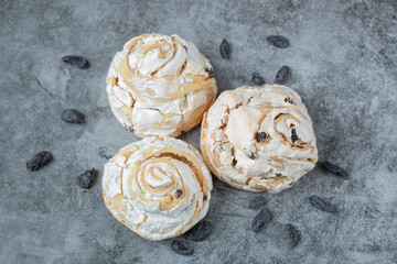 Fried meringue cookie with black raisines on the grey marble background