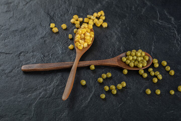 Fototapeta na wymiar Two wooden spoon with canned corns and olives