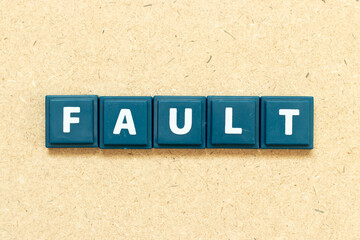 Tile alphabet letter in word fault on wood background