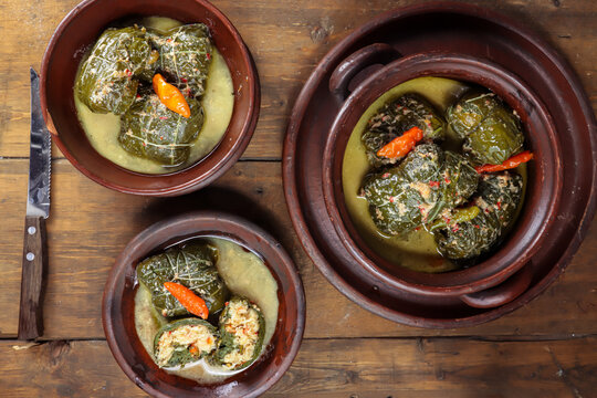 Buntil daun singkong is traditional indonesian food made from cassava leaves Stuffed with grated coconut, petai cina, and anchovy fish. Served on traditional plate