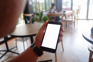 Mockup picture of business woman’s hands holding smart phone with white blank screen in modern place