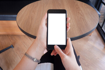 Mockup picture of business woman’s hands holding smart phone with white blank screen in modern place