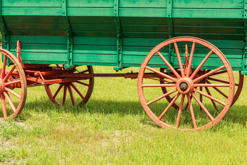 Fototapeta na wymiar vintage green cart on green grass on a summer sunny day