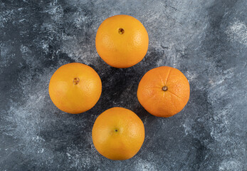 Four tasty oranges on marble background