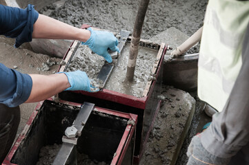 Pouring Concrete mix into mold and using concrete vibrator - 416669092