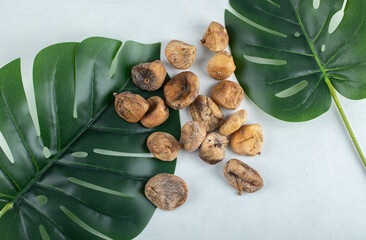 Dried figs with green leaves on white background