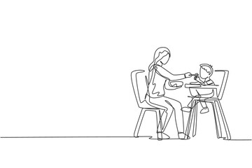 One single line drawing of young mother feeding her son a meal who sit at baby dining chair at home vector graphic illustration. Happy family parenting concept. Modern continuous line draw design