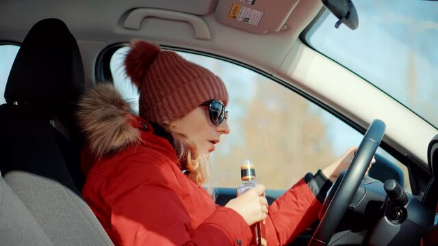Drunk Driver Sitting On Car.Tired Woman Illegal Vehicle Driving.Drunken Drive Risk Car Accident.Holding Alcohol Bottle In Car. Dangerous On Road Drunk Driver.Stress Unlawful Intoxicated Driving Auto