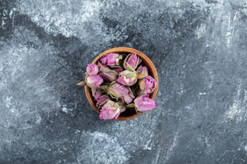 Small budding roses in wooden bowl