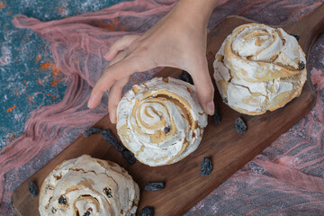 Fluffy meringue muffins with black dry grapes on the table