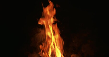Fire flame background. Bonfire on black. Hot blaze texture. Passion energy. Orange yellow burn smoke sparks motion at night isolated on dark.