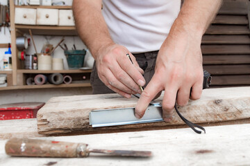 Male carpenter working with wood material in a garage.